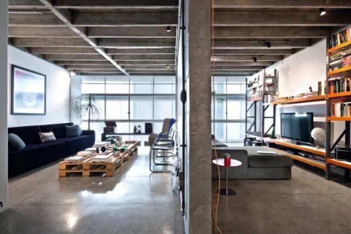 LIVING | A parede estrutural divide a área social. A sala de estar tem sofá de 3,50 m de largura feito sob encomenda pela Fernando Jaeger Atelier, mesa de centr